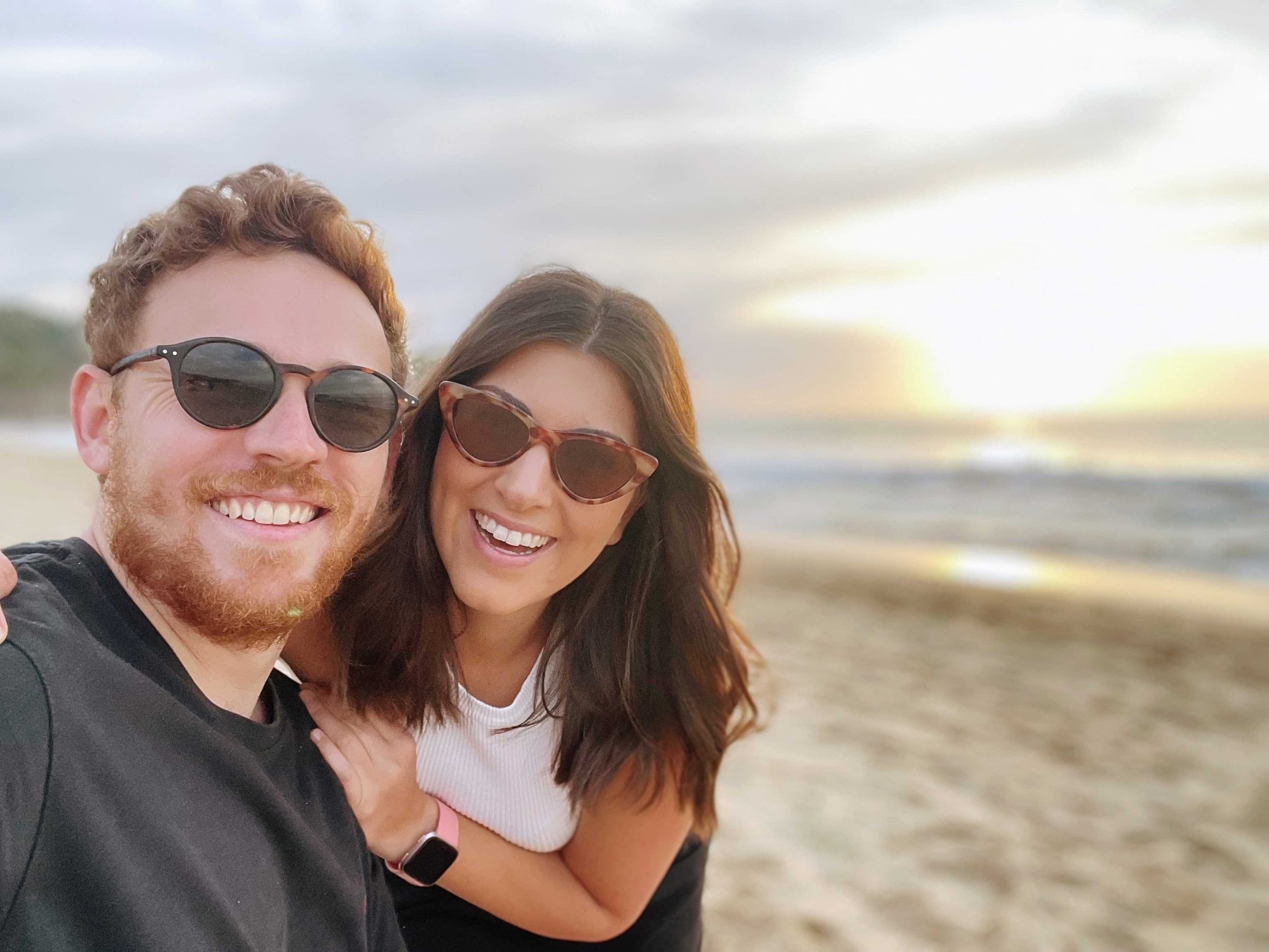 Aussies in the Wild Travel Bloggers Laura and Andrew smiling on a beach