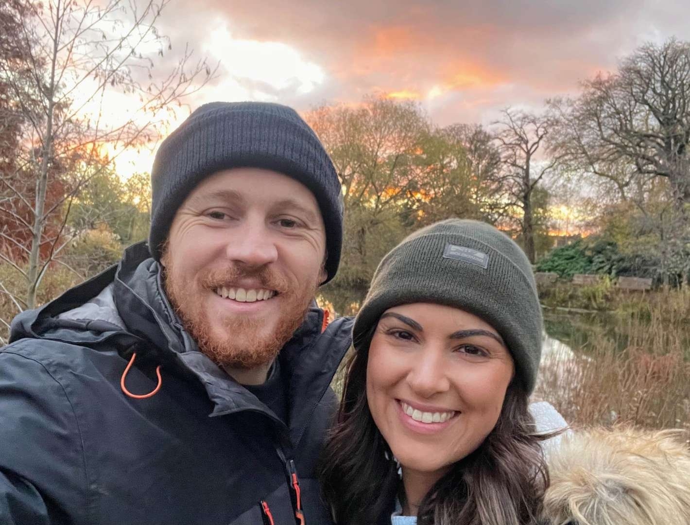 Travel couple Andrew and Laura smiling at sunset in a UK park