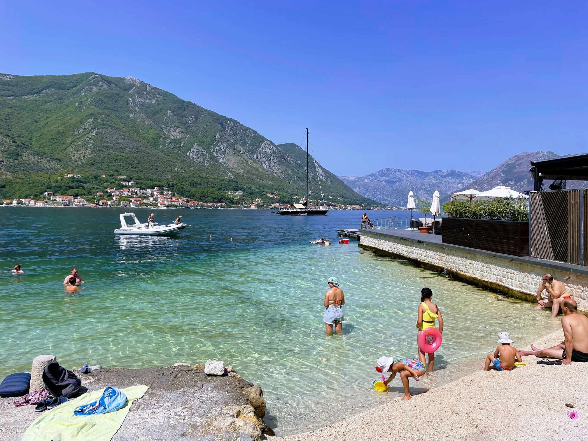 Families swimming in the crystal waters of Montenegro's coastal town of Kotor