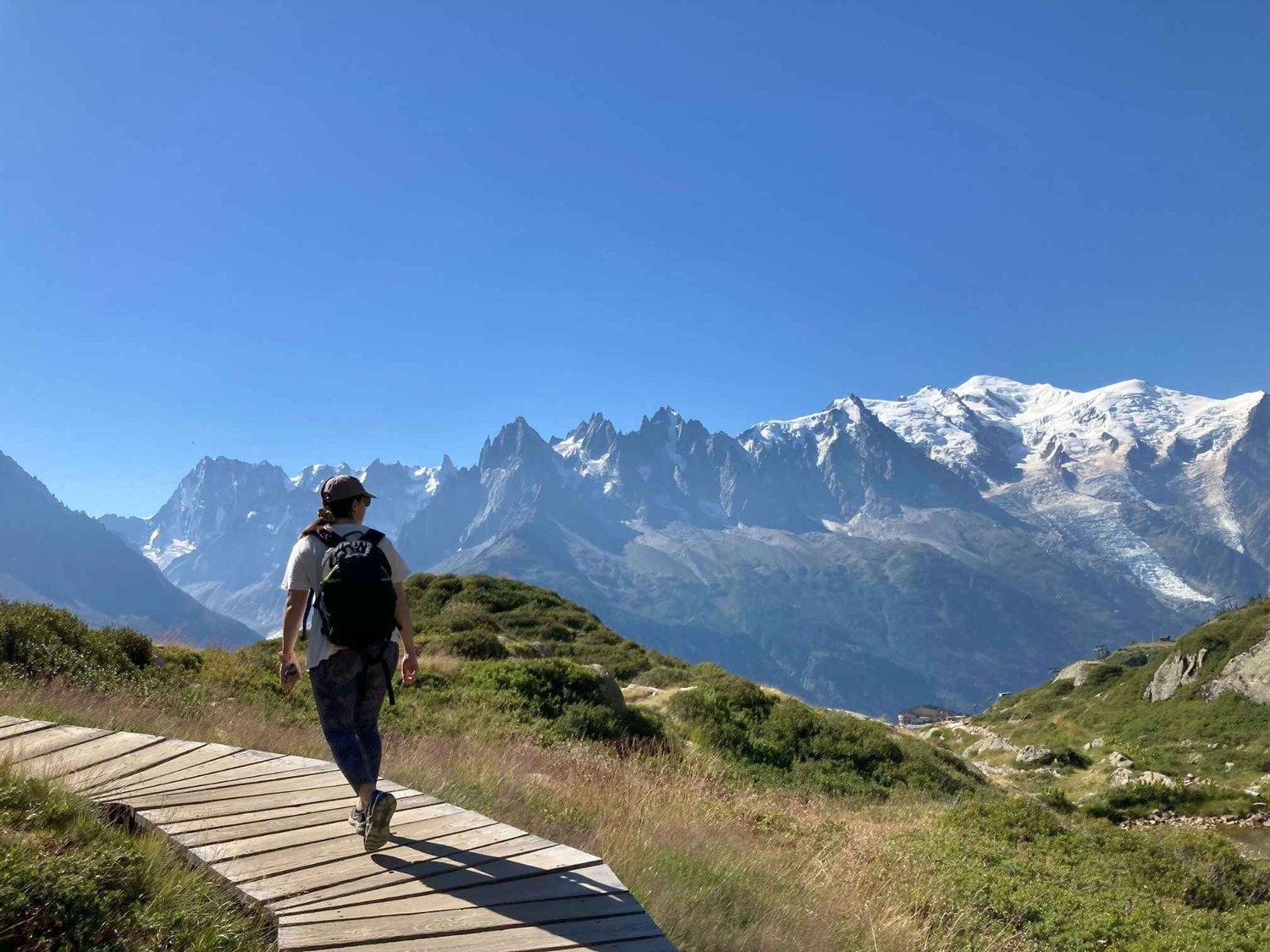 Laura walking on a pathed section of the Lac Blanc hike from La Flégère looking out to snow-capped Mont Blanc.