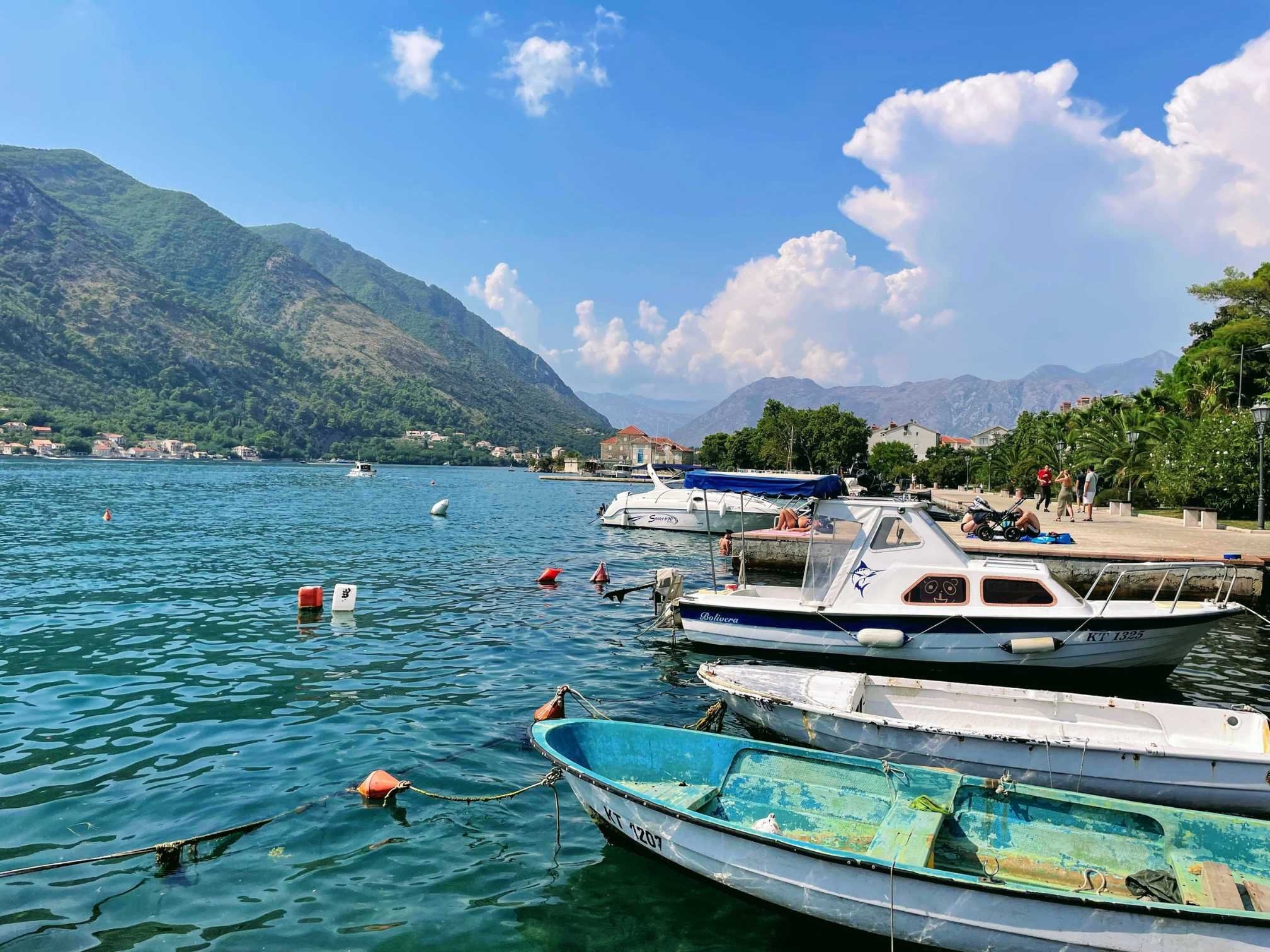 Boats docket in the quiet Bay of Kotor surrounded by mountain views