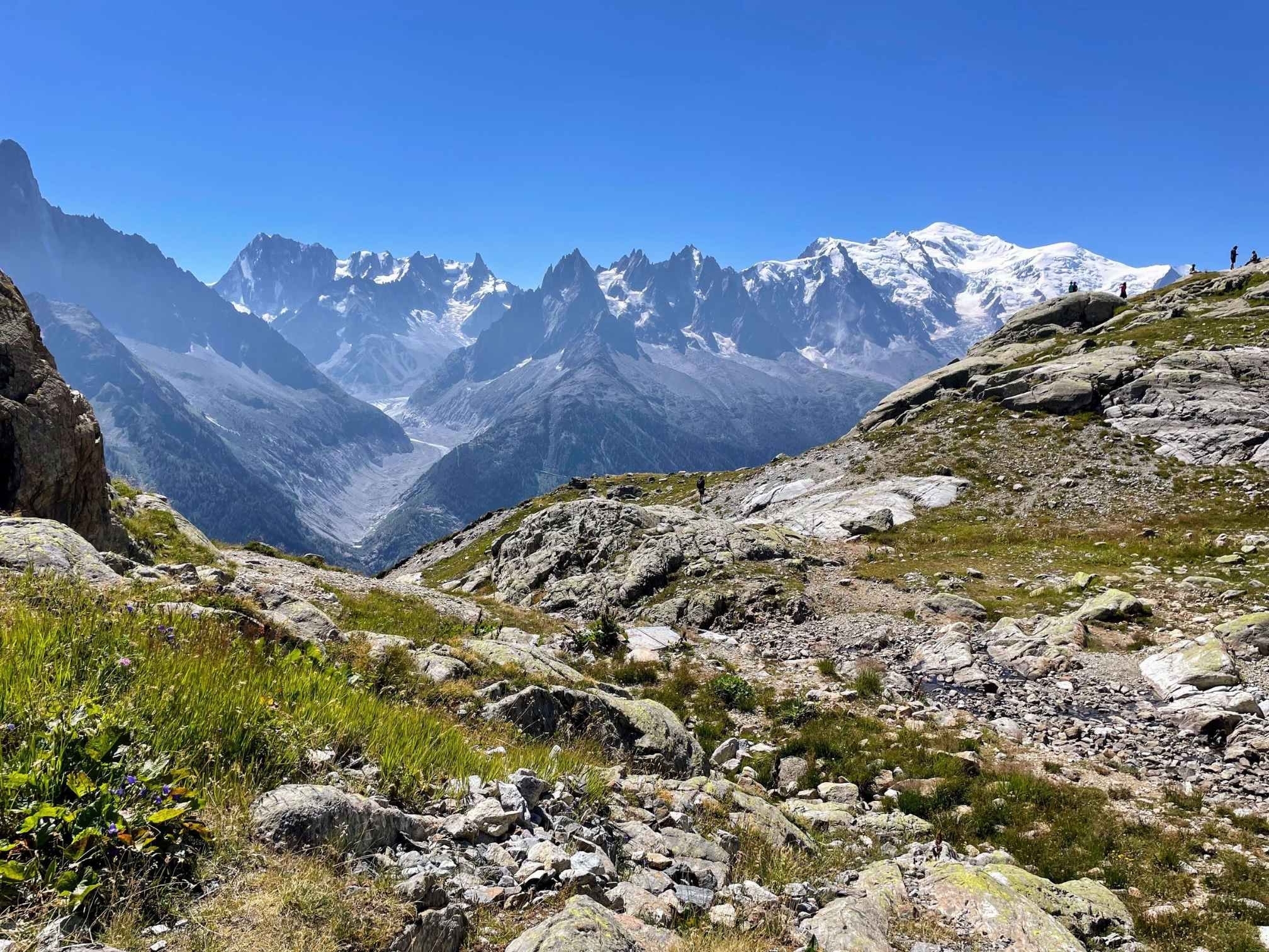 Rocky, uneven Lac Blanc hike path from L'Index to Lac Blanc in Chamonix, with stunning Mont-Blanc backdrop and blue skies.