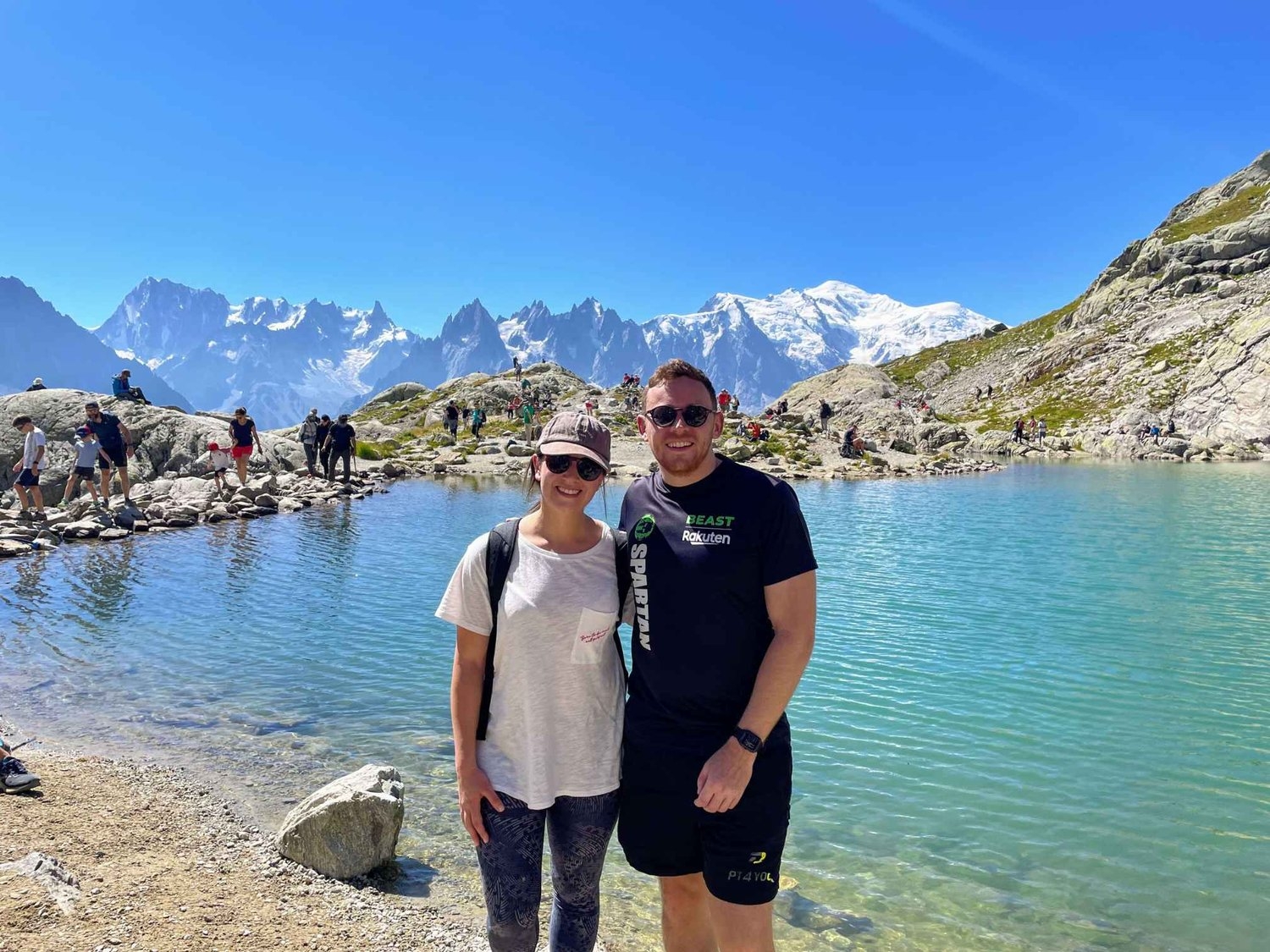 Travel couple Andrew and Laura smiling at Lac Blanc on a sunny summers day